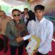 Pj. Sekda  Kabupaten Gorontalo Haris Tome saat menyerahkan Ijazah kepada 438 Siswa Paket A, B , dan C di SKB Limboto, Kamis (19/09/2024). (Foto : Dok. Humas)