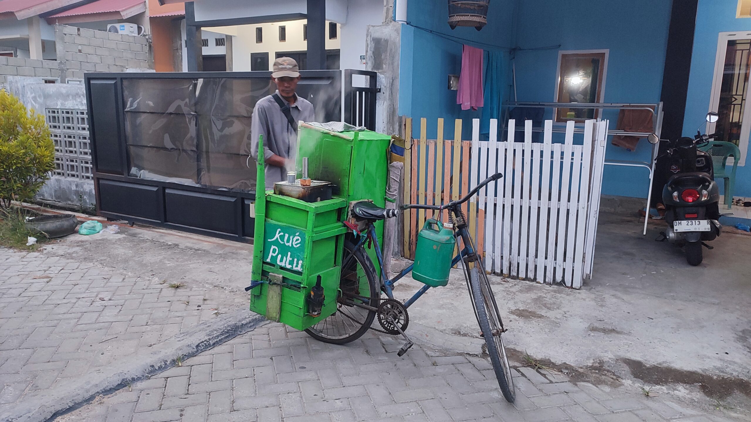Keterangan Foto : Tora Penjual Kue Putu. (komparasi.id)